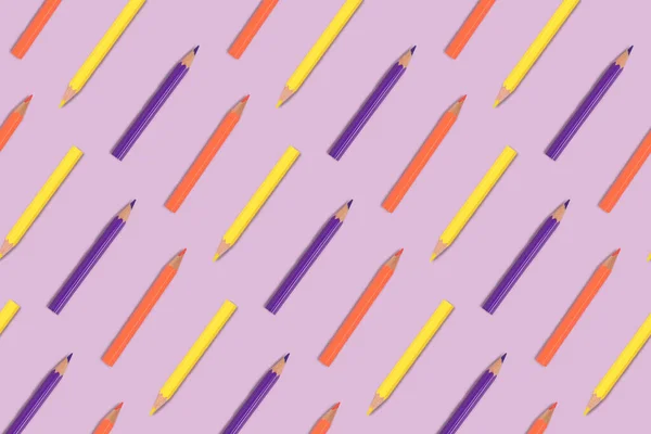 Color pencils pattern on a purple pastel background.