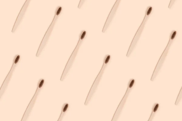 Toothbrushes pattern on a beige background. Zero waste creative concept.