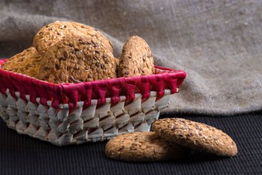 Tuzlu kurabiye üzerinde bir ahşap masa ve çuval bezi arka plan ayçiçeği susam serpilir