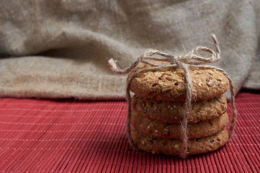 ayçiçeği tohumu ve çuval bezi arka plan üzerinde kırmızı kareli sepet yakın ev yapımı yulaf kurabiye