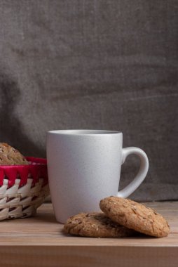 Yulaf ezmeli kurabiye yakınındaki gri çay fincan ayçiçeği tohumu ile.
