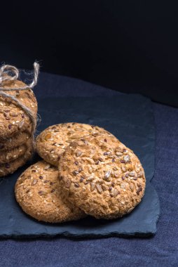 Tuzlu kurabiye yığını susam, ayçiçeği şeyl tahtada ve iki coockis ile serpilir