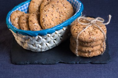Tuzlu kurabiye yığını susam, ayçiçeği şeyl tahtada ve iki coockis ile serpilir