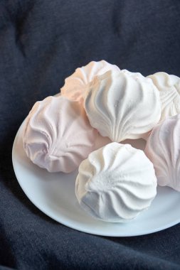 Beyaz ve pembe zephyr yakın koyu arka plan üzerinde beyaz bir plaka üzerinde çekim