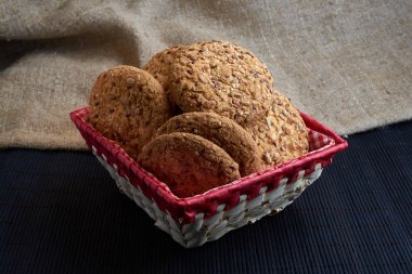 Tuzlu kurabiye üzerinde bir ahşap masa ve çuval bezi arka plan ayçiçeği susam serpilir