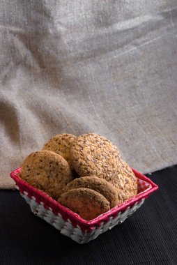 Tuzlu kurabiye üzerinde bir ahşap masa ve çuval bezi arka plan ayçiçeği susam serpilir