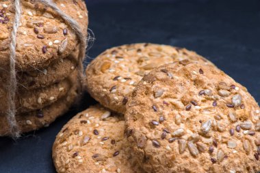 Tuzlu kurabiye yığını susam, ayçiçeği şeyl tahtada ve iki coockis ile serpilir