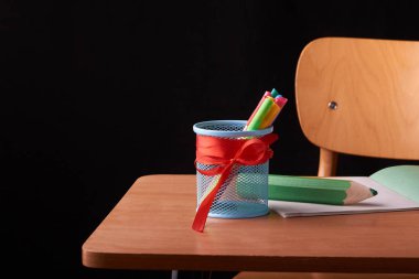 Renkli kalemler ahşap bir masa üzerinde bir bardak. Konsept: okula