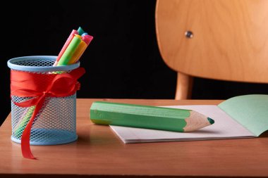 geri okul kavramı ve izole okul masasında kalemler için tutucu