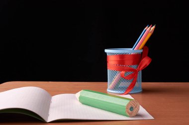 Yazı tahtası önünde büyük yeşil kalem ile sınıf tabloda okul ve ofis malzemeleri. Kopya alanı ile göster