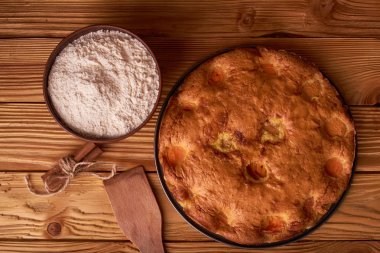 kayısı pasta ve bir kase un ve diğer malzemeler ahşap tablo