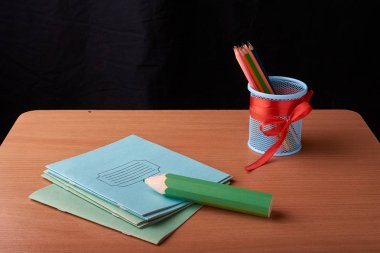 Yeşil büyük kalem ve siyah arka plan üzerine izole masa üzerinde boya kalemi ile metal Kupası