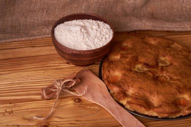 kayısı pasta ve bir kase un ve diğer malzemeler ahşap tablo