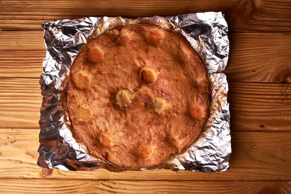Folyo ahşap bir masa üzerinde pişmiş kayısı