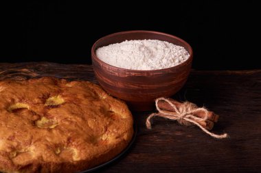 kayısı pasta ve bir kase un ve diğer malzemeler ahşap tablo