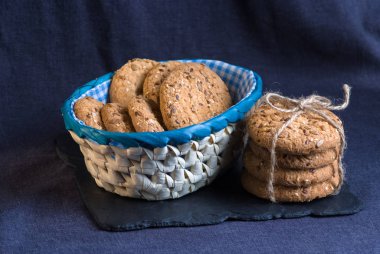 Tuzlu kurabiye yığını susam, ayçiçeği şeyl tahtada ve iki coockis ile serpilir