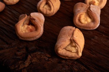 Kurabiyeleri süzme peynir ile fırında, ahşap masa ve siyah arka plan üzerinde. Yakın, seçici odak. Ev yapımı gıda kavramı