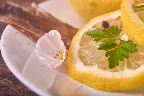 Аппетитная запечённая рыба, покрытая сочными лимонами, чесноком и солью сбоку, вид сверху — стоковое фото