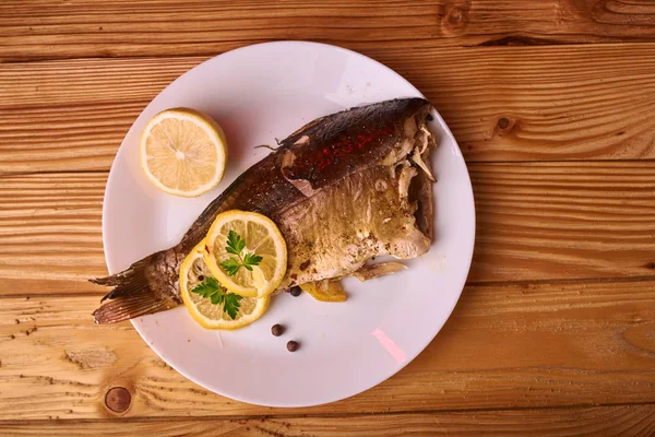 Pesce alla griglia con erbe aromatiche e limone su fondo di legno. Mediterraneo concetto di frutti di mare di lusso — Foto Stock