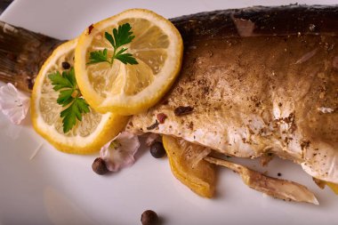 Kavrulmuş sazan ile ahşap masa tabakta dorado balık maydanoz, chives ve limon ile