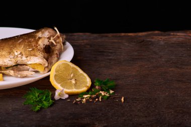 Bir dilim limon ile balık tabağını yakınındaki bir ahşap zemin üzerine baharat