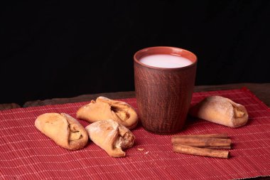 Süzme peynir kurabiye parçaya nibbled. allık cam ahşap masa üzerinde süt pişirme ve kil. tatlı ve lezzetli kurabiye