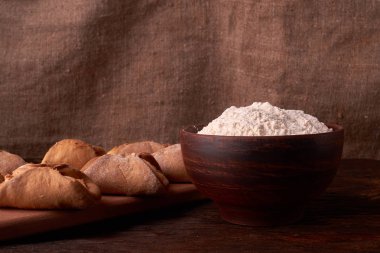 un, kil kase ürünlerinde cheesecakes Ahşap Doğrama tahtası üzerinde yapmak için. Siyah arka plan üzerine ev yapımı peynir kurabiye