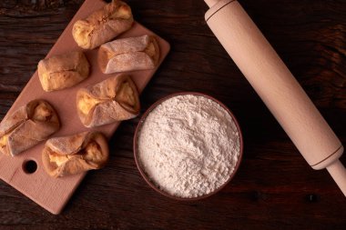 un, kil kase ürünlerinde cheesecakes Ahşap Doğrama tahtası üzerinde yapmak için. Siyah arka plan üzerine ev yapımı peynir kurabiye