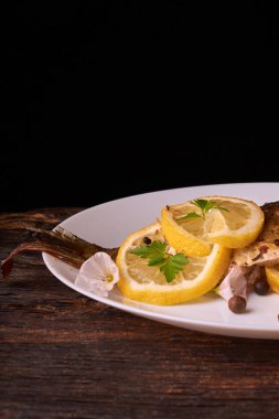 Otlar ve ahşap zemin, üstten görünüm üzerine limon ile ızgara balık. Akdeniz lüks deniz ürünleri kavramı