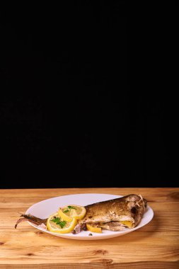Otlar ve ahşap zemin, üstten görünüm üzerine limon ile ızgara balık. Akdeniz lüks deniz ürünleri kavramı