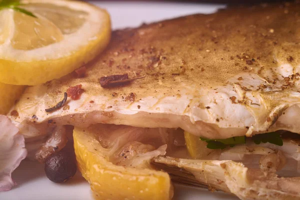 Otlar ve ahşap zemin, üstten görünüm üzerine limon ile ızgara balık. Akdeniz lüks deniz ürünleri kavramı