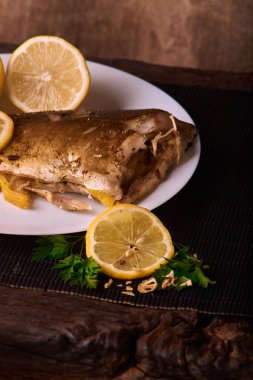 Kavrulmuş sazan ile ahşap masa tabakta dorado balık maydanoz, chives ve limon ile