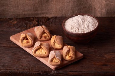 un, kase süzme peynir ve süt bir sürahi. yumurta. cheesecakes Ahşap Doğrama tahtası üzerinde yapmak için ürünler