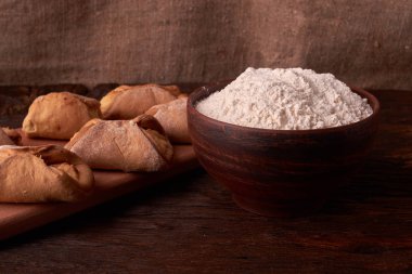 un, kase süzme peynir ve süt bir sürahi. yumurta. cheesecakes Ahşap Doğrama tahtası üzerinde yapmak için ürünler