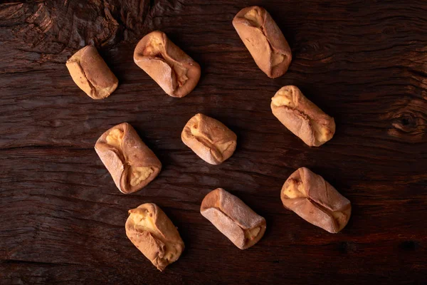 Ev yapımı çörekler ahşap arka plan üzerinde süzme peynir ile doldurulmuş. Seçici odak.