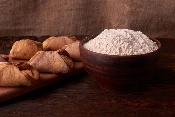 un, kase süzme peynir ve süt bir sürahi. yumurta. cheesecakes Ahşap Doğrama tahtası üzerinde yapmak için ürünler