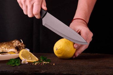 Tanınmayan kadın kesme taze limon yemek mutfakta, eller yakın çekim görünümünü için ahşap tahta üzerinde