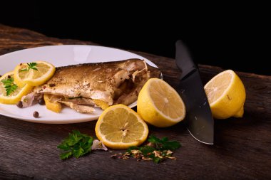 limon dilimleri, baharat ve fırın tepsisine, taze biberiye ile lezzetli kavrulmuş sazan balık yukarıdan görüntülemek