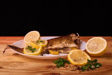 limon dilimleri, baharat ve fırın tepsisine, taze biberiye ile lezzetli kavrulmuş sazan balık yukarıdan görüntülemek