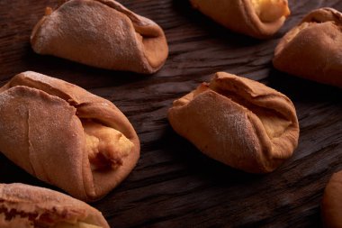 Ev yapımı çörekler ahşap arka plan üzerinde süzme peynir ile doldurulmuş. Seçici odak.