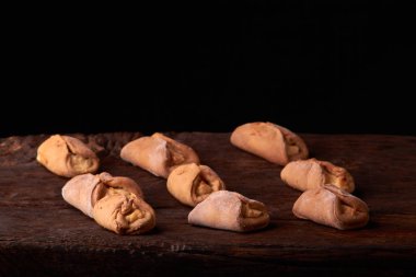 Ev yapımı çörekler ahşap arka plan üzerinde süzme peynir ile doldurulmuş. Seçici odak.