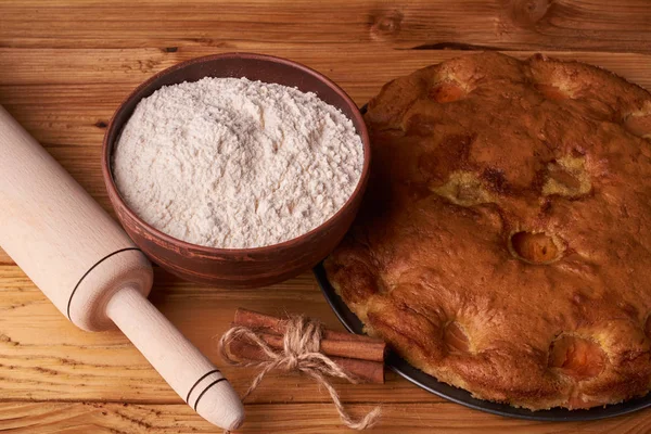 kayısı pasta ve bir kase un ve diğer malzemeler ahşap tablo