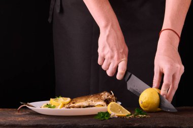 Tanınmayan kadın kesme taze limon yemek mutfakta, eller yakın çekim görünümünü için ahşap tahta üzerinde