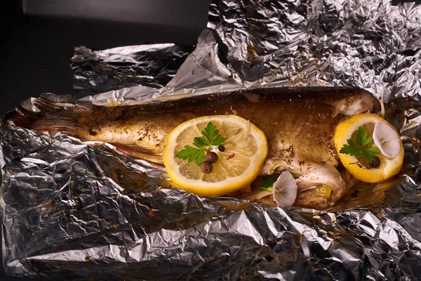 limon dilimleri, baharat ve fırın tepsisine, taze biberiye ile lezzetli kavrulmuş sazan balık yukarıdan görüntülemek