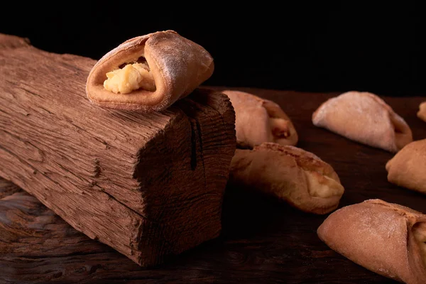 Kurabiyeleri süzme peynir ile fırında, ahşap masa ve siyah arka plan üzerinde. Yakın, seçici odak.