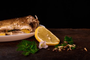 Kavrulmuş sazan ile ahşap masa tabakta dorado balık maydanoz, chives ve limon ile