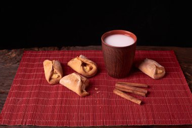 Süzme peynir kurabiye parçaya nibbled. allık cam ahşap masa üzerinde süt pişirme ve kil. tatlı ve lezzetli kurabiye