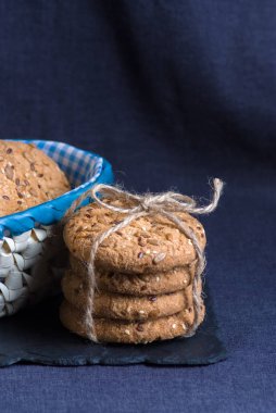 Tuzlu kurabiye yığını susam, ayçiçeği şeyl tahtada ve iki coockis ile serpilir