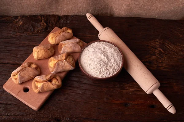 un, kil kase ürünlerinde cheesecakes Ahşap Doğrama tahtası üzerinde yapmak için. Siyah arka plan üzerine ev yapımı peynir kurabiye