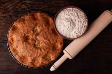 kayısı pasta ve bir kase un ve diğer malzemeler ahşap tablo